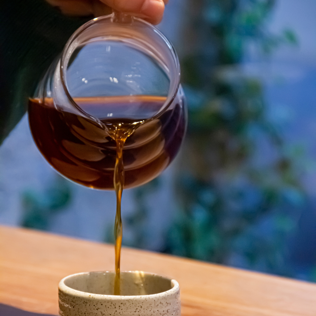 Immagine di una tazza di caffè filtro appena preparato, con sfumature di colore marrone intenso.La scena cattura la semplicità e l'eleganza della preparazione del caffè specialty, mettendo in risalto la ricchezza dei suoi aromi.
